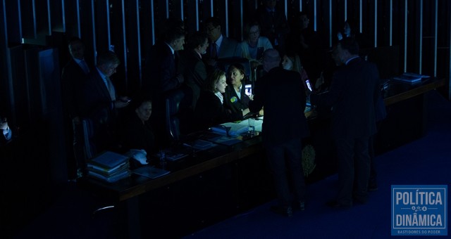 O presidente Eunício Oliveira mandou desligar as luzes do plenário e as senadoras permaneceram na mesa Regina, ao lado de Gleisi e Fátima, enquanto o presidente Eunício tenta assumir a presidência (Foto: Lula Marques/AGPT)