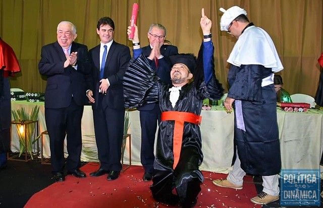 Padre Walmir de joelhos após receber o canudo (Foto: Reprodução/Facebook)